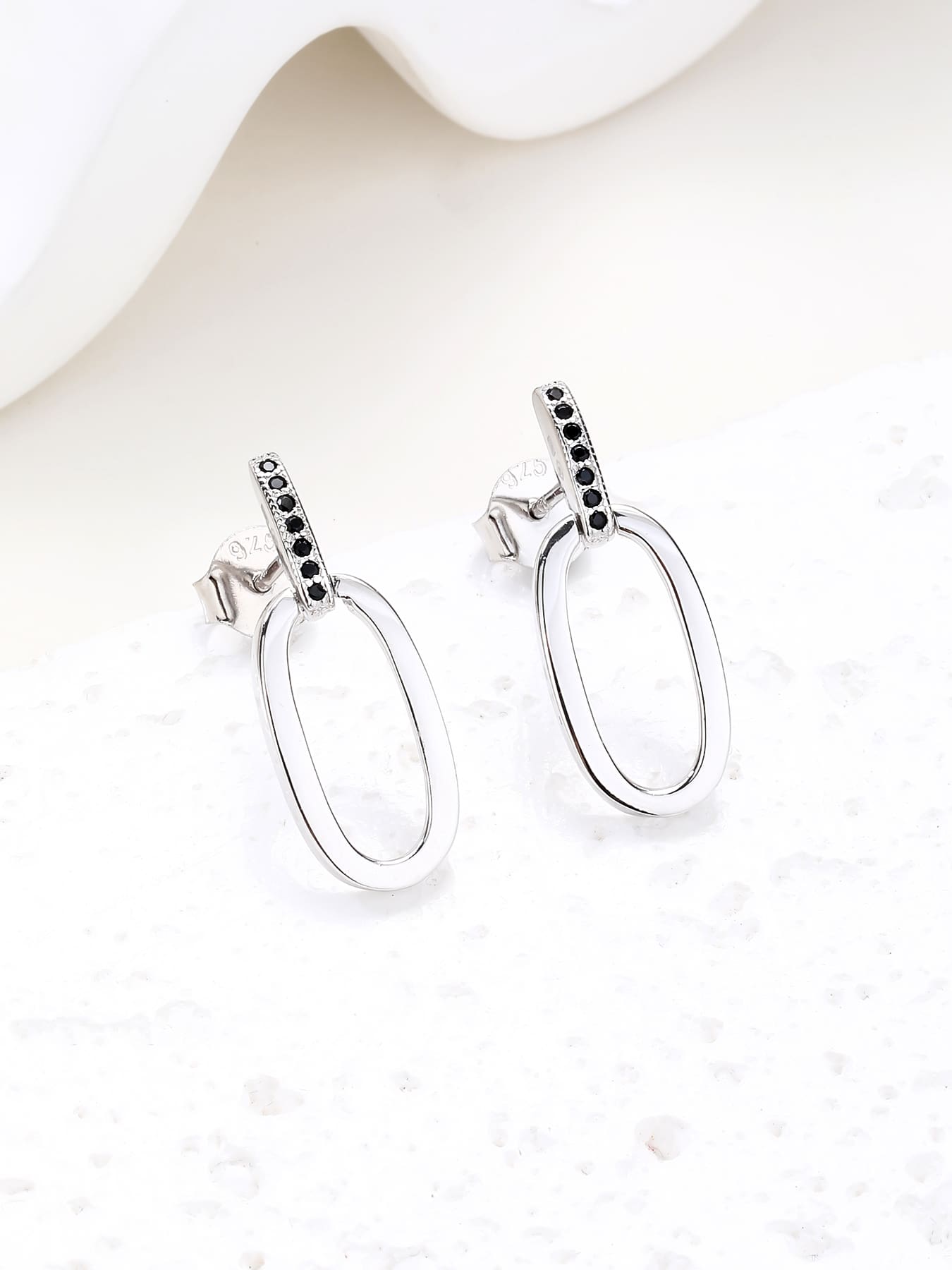 Black zirconia oval dangle earrings in hallmarked, rhodium-plated 925 sterling silver – display view – DRESCHER Jewellery®