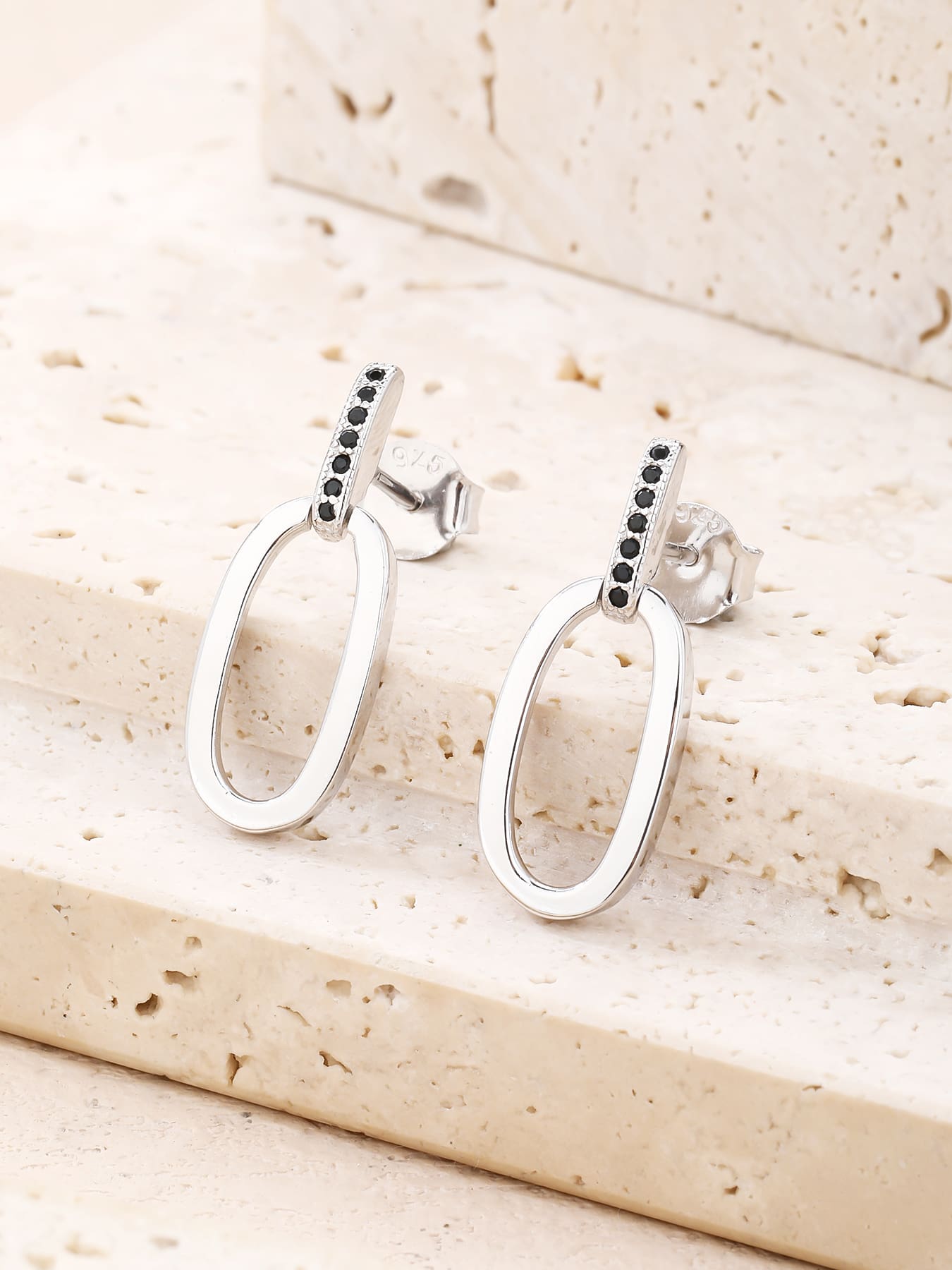 Black zirconia oval dangle earrings in hallmarked, rhodium-plated 925 sterling silver – lifestyle view – DRESCHER Jewellery®