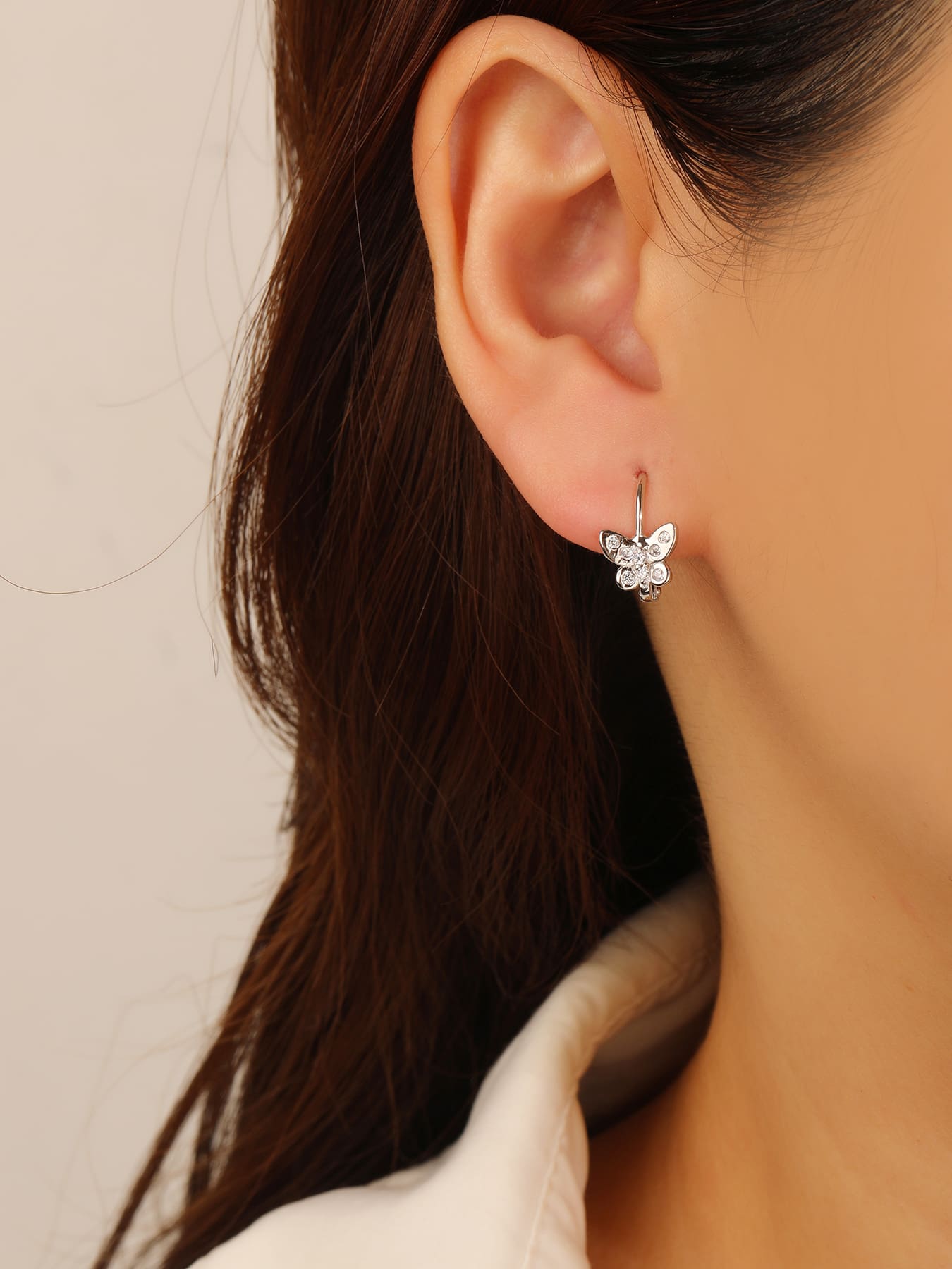 White cubic zirconia butterfly leverback earrings in hallmarked, rhodium-plated 925 sterling silver – worn view – DRESCHER Jewellery®