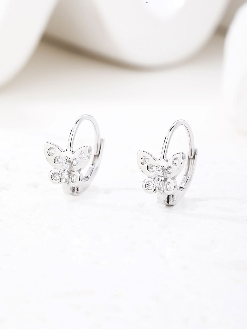 White cubic zirconia butterfly leverback earrings in hallmarked, rhodium-plated 925 sterling silver – display view – DRESCHER Jewellery®