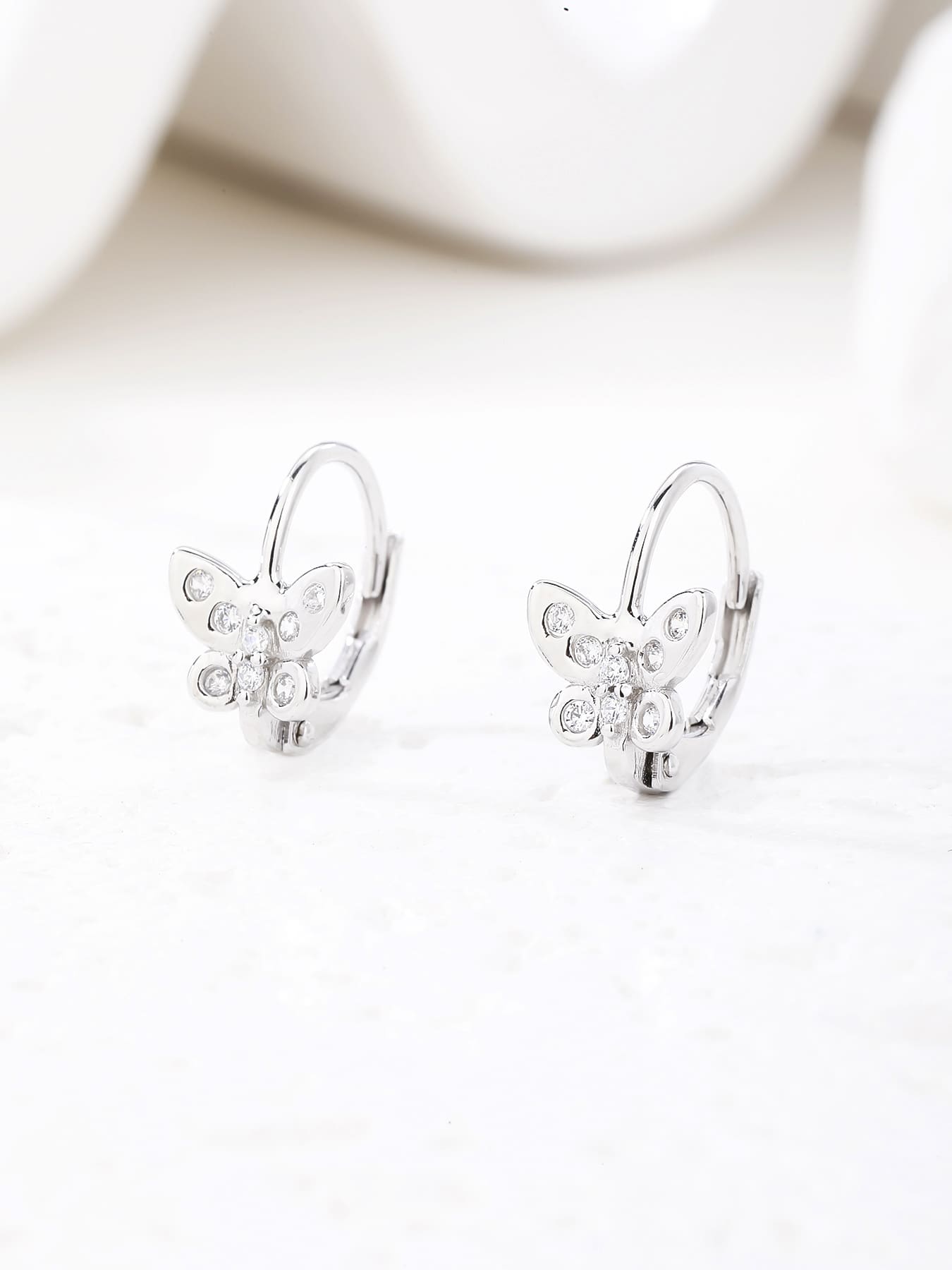 White cubic zirconia butterfly leverback earrings in hallmarked, rhodium-plated 925 sterling silver – display view – DRESCHER Jewellery®