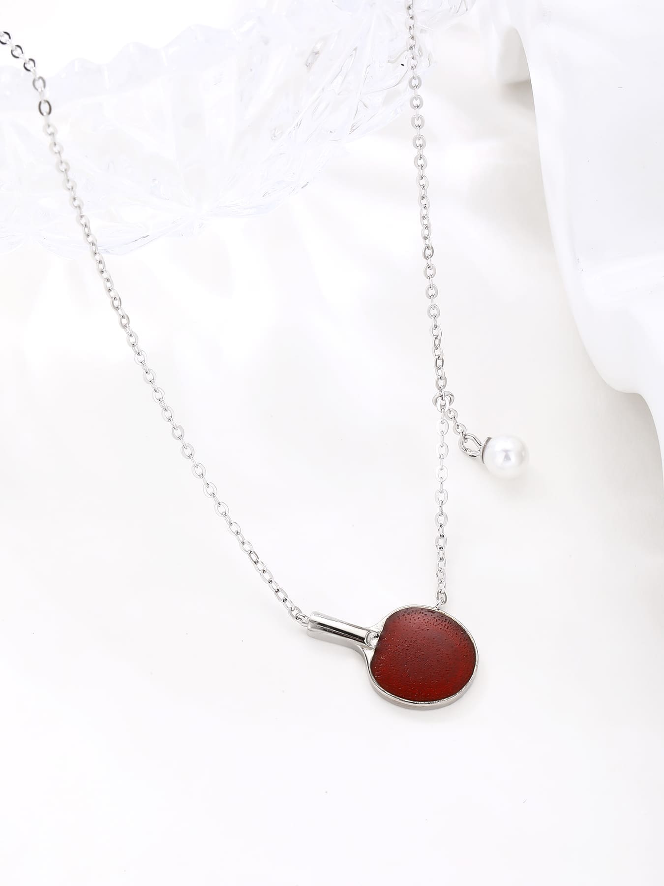 Burgundy enamel table-tennis paddle and pearl ball pendant necklace, crafted with hallmarked, rhodium-plated 925 sterling silver – lifestyle view – DRESCHER Jewellery®