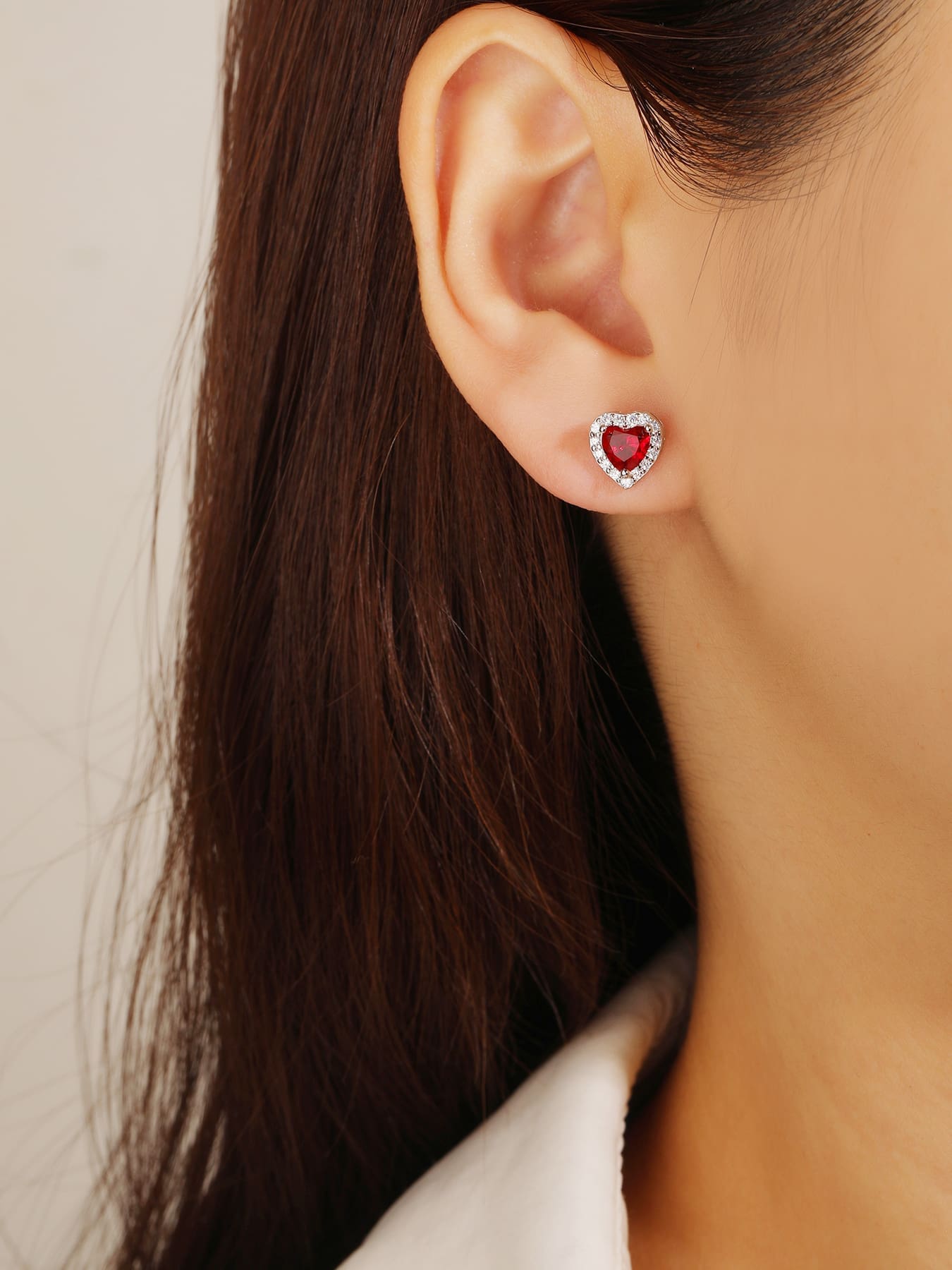 Red heart and white cubic zirconia stud earrings in hallmarked, rhodium-plated 925 sterling silver – worn view – DRESCHER Jewellery®