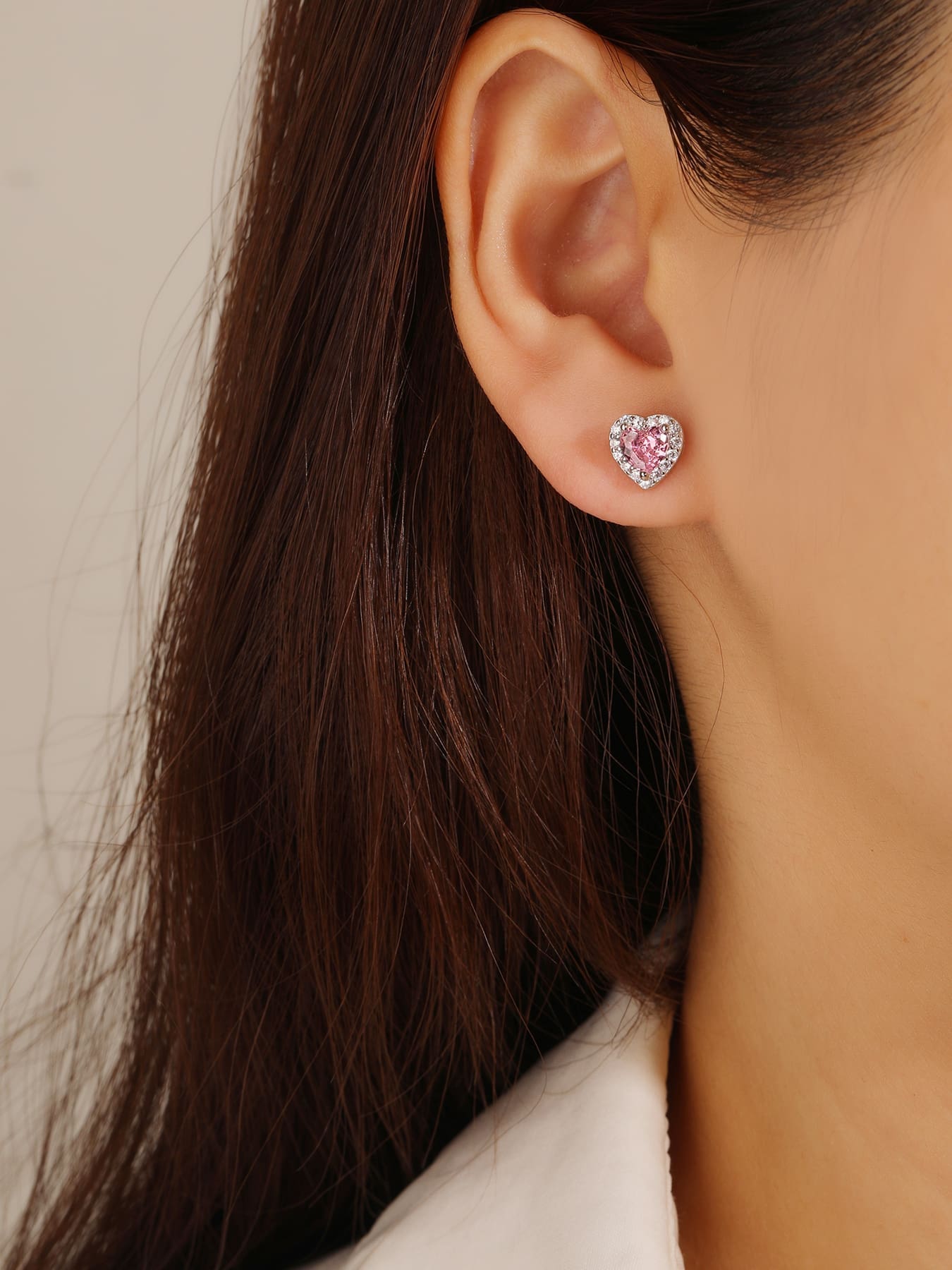 Pink heart and white cubic zirconia stud earrings in hallmarked, rhodium-plated 925 sterling silver – worn view – DRESCHER Jewellery®