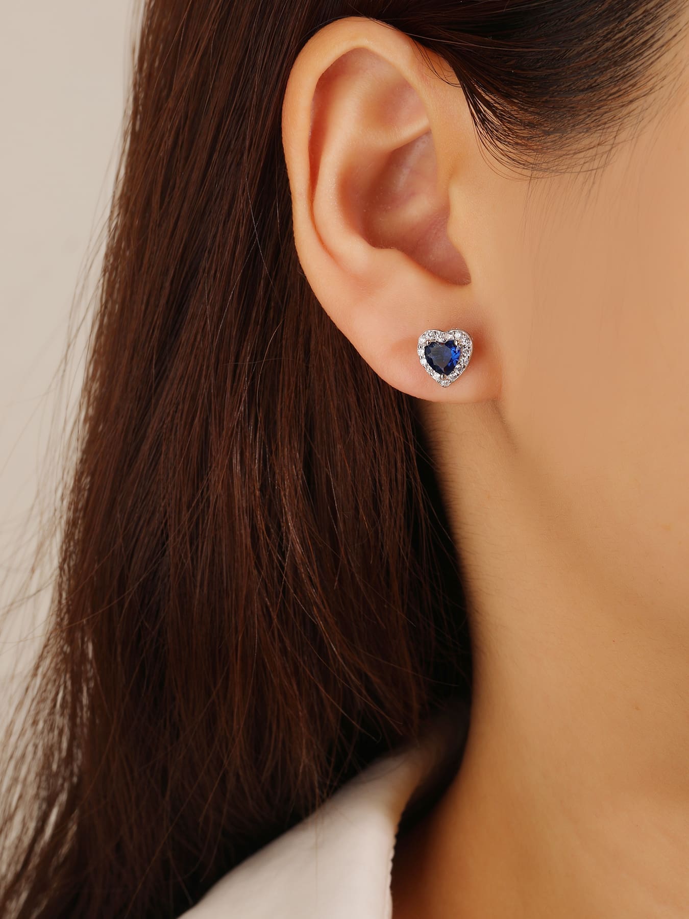 Dark blue heart and white cubic zirconia halo stud earrings in hallmarked, rhodium-plated 925 sterling silver – worn view – DRESCHER Jewellery®
