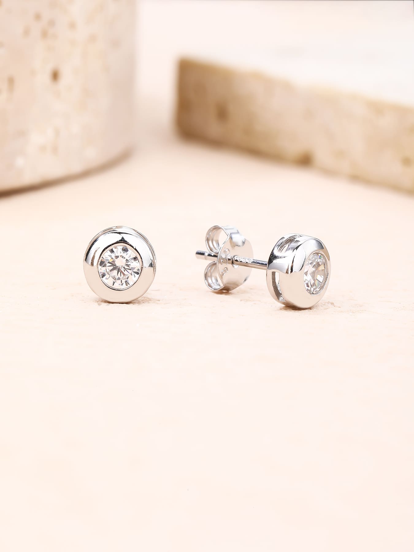 White cubic zirconia button-set stud earrings in hallmarked, rhodium-plated 925 sterling silver – lifestyle view – DRESCHER Jewellery®