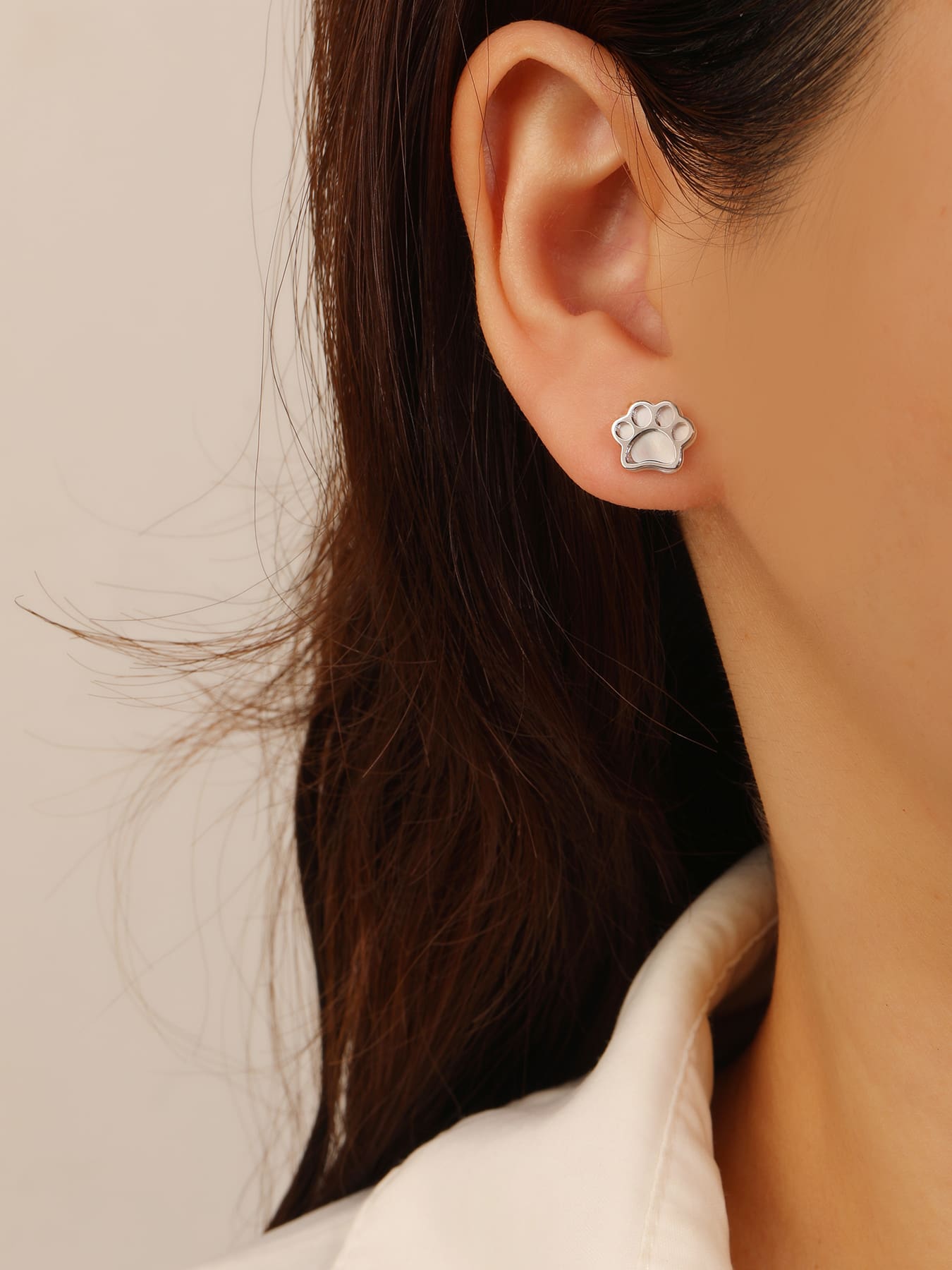 Paw-print stud earrings with mother-of-pearl inlays and silver components crafted from hallmarked, rhodium-plated 925 sterling silver – worn view – DRESCHER Jewellery®