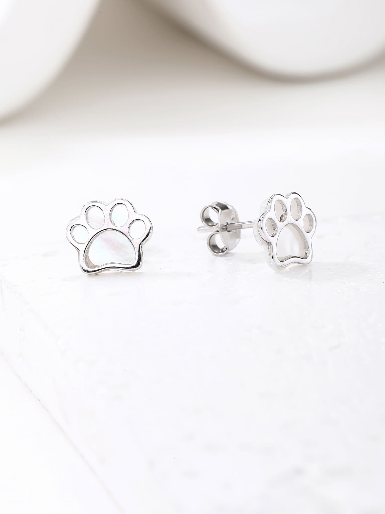 Paw-print stud earrings with mother-of-pearl inlays and silver components crafted from hallmarked, rhodium-plated 925 sterling silver – display view – DRESCHER Jewellery®