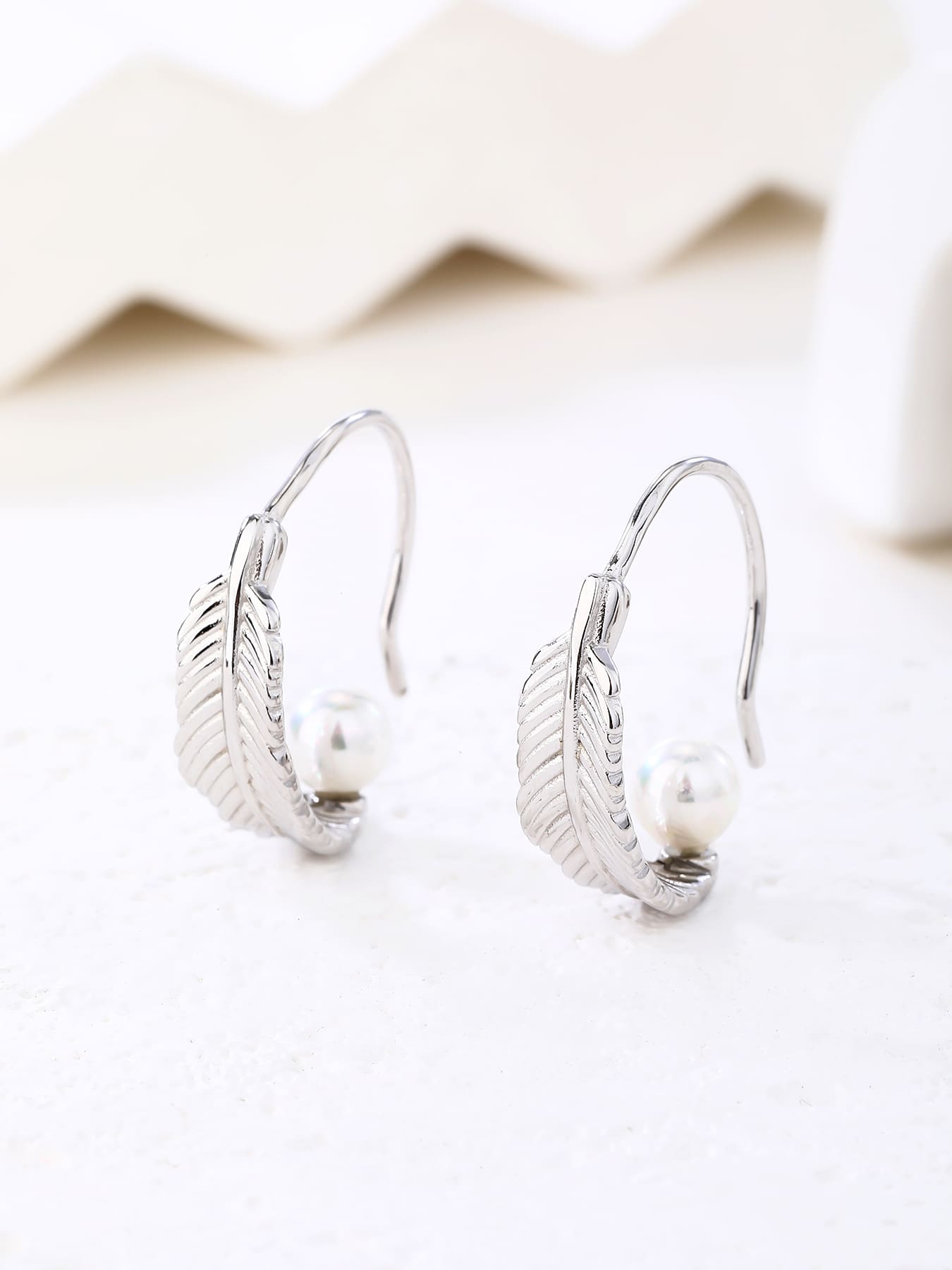 White pearl feather earrings, with silver components crafted from hallmarked, rhodium-plated 925 sterling silver – display view – DRESCHER Jewellery®