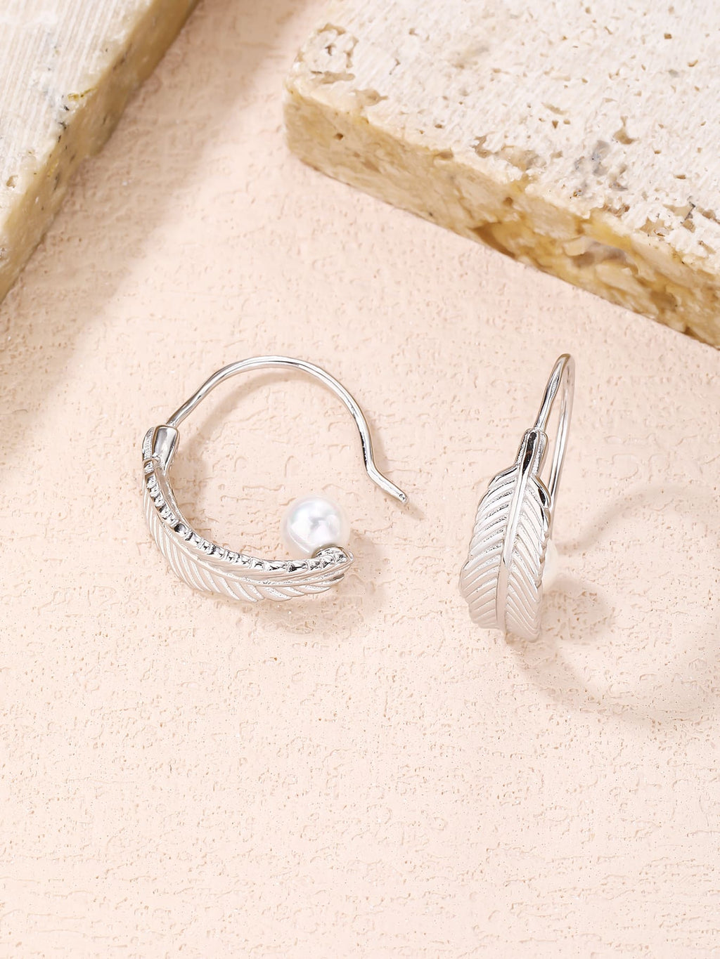 White pearl feather earrings, with silver components crafted from hallmarked, rhodium-plated 925 sterling silver – lifestyle view – DRESCHER Jewellery®