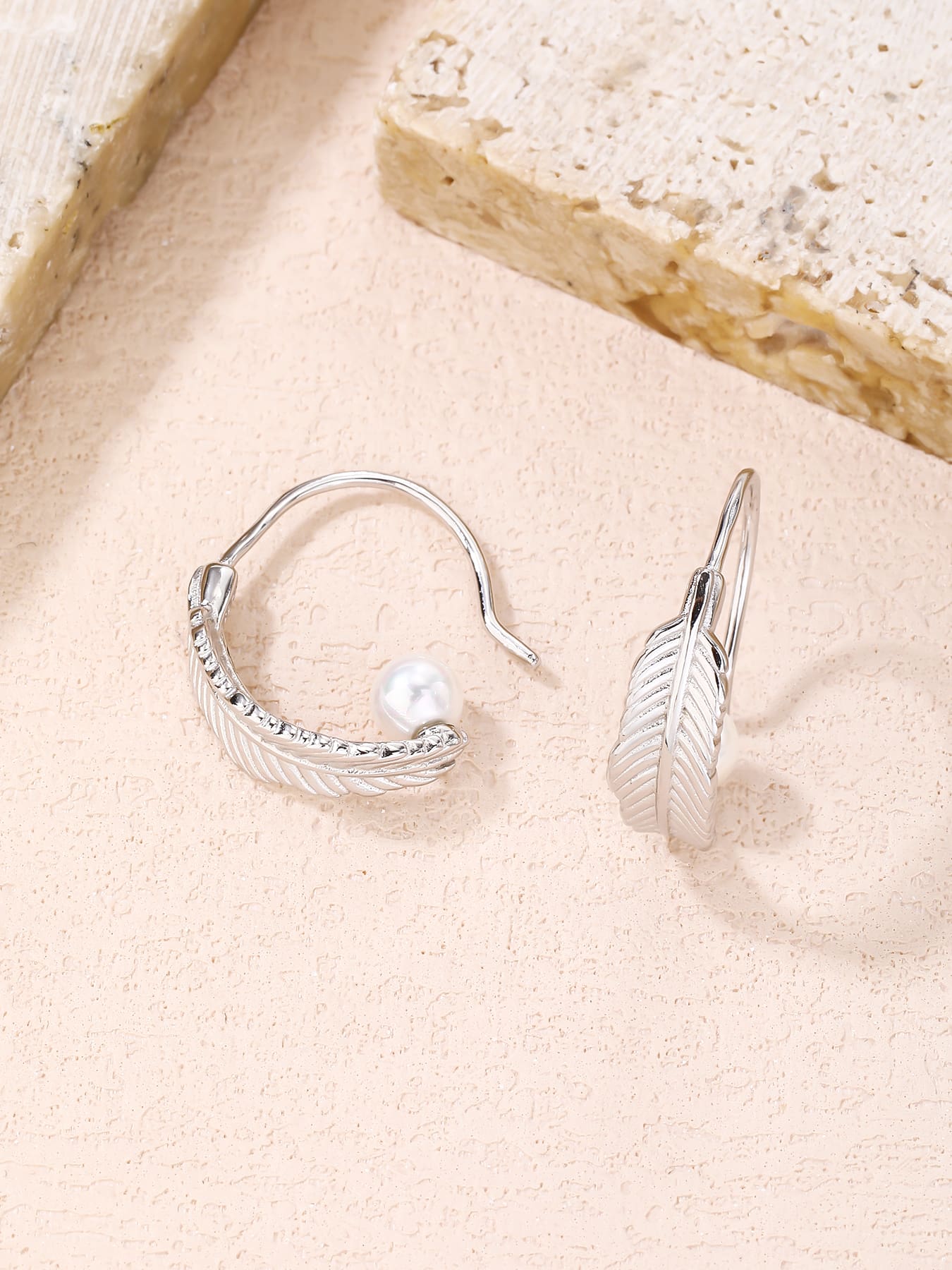 White pearl feather earrings, with silver components crafted from hallmarked, rhodium-plated 925 sterling silver – lifestyle view – DRESCHER Jewellery®