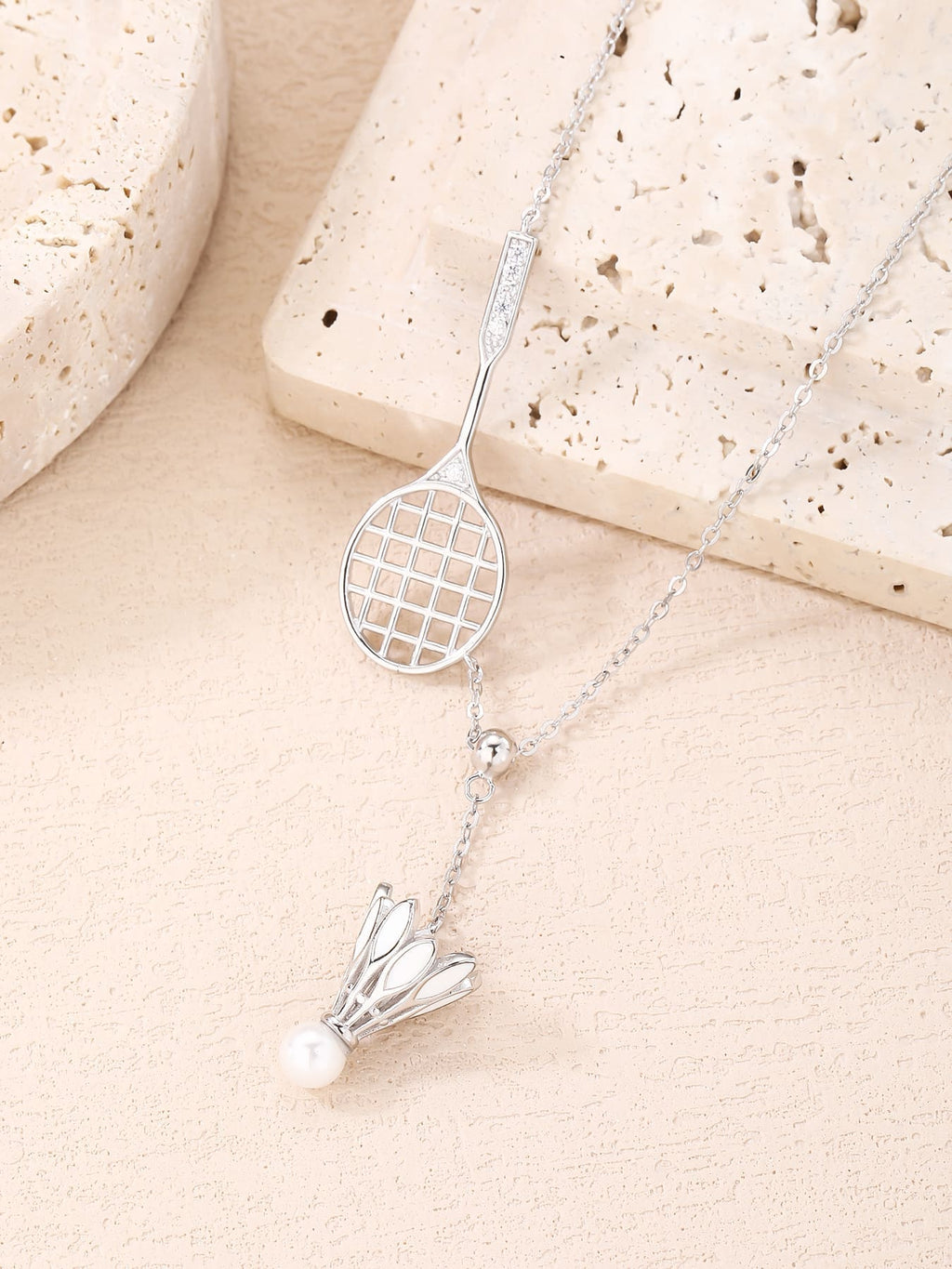 Badminton racket and shuttlecock pendant necklace with white cubic zirconia and pearl detail, crafted with hallmarked, rhodium-plated 925 sterling silver – lifestyle view – DRESCHER Jewellery®