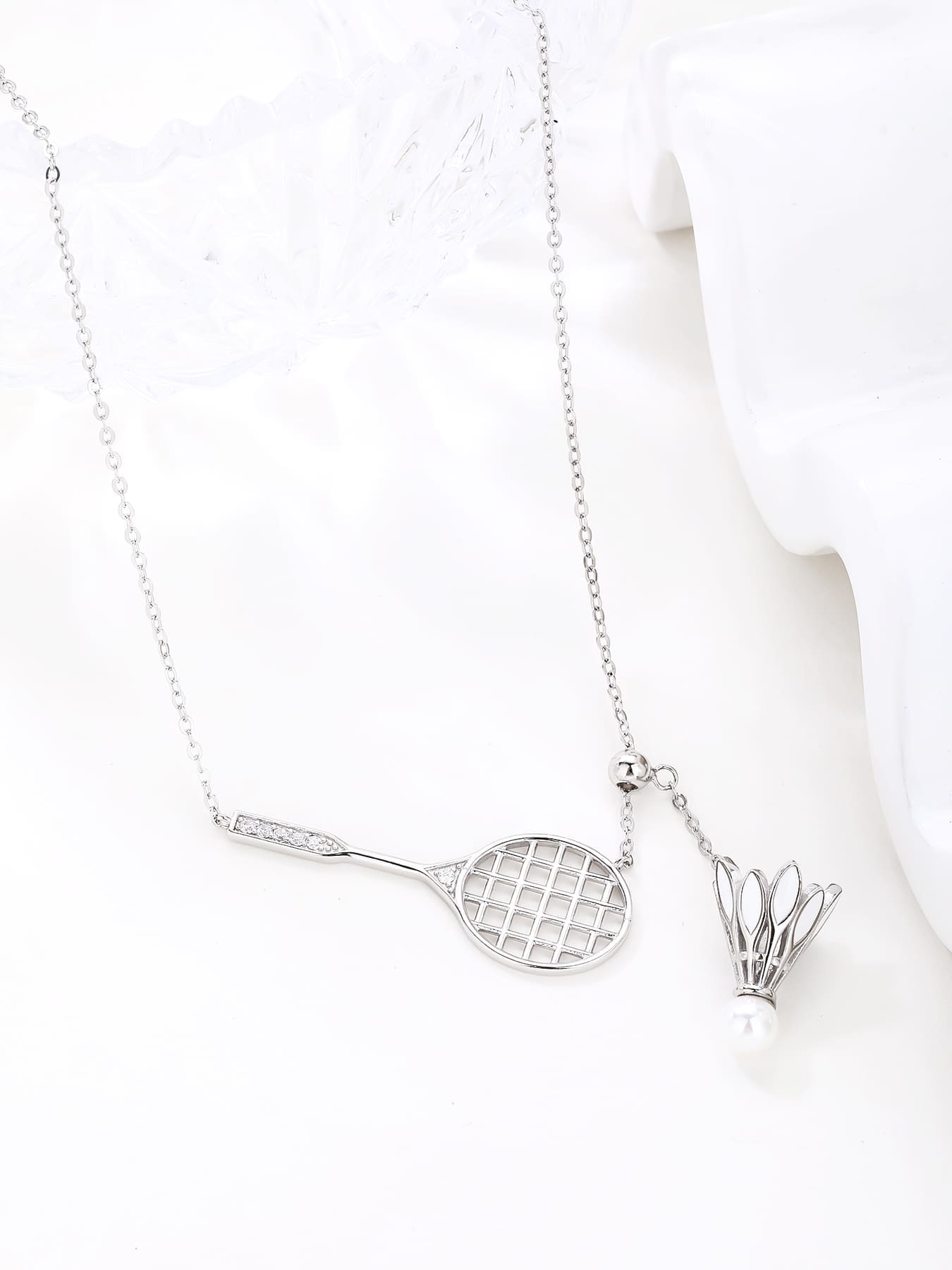 Badminton racket and shuttlecock pendant necklace with white cubic zirconia and pearl detail, crafted with hallmarked, rhodium-plated 925 sterling silver – display view – DRESCHER Jewellery®