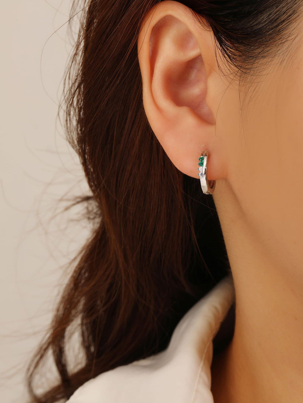 Green and white cubic zirconia hoop earrings in hallmarked, rhodium-plated 925 sterling silver – worn view – DRESCHER Jewellery®