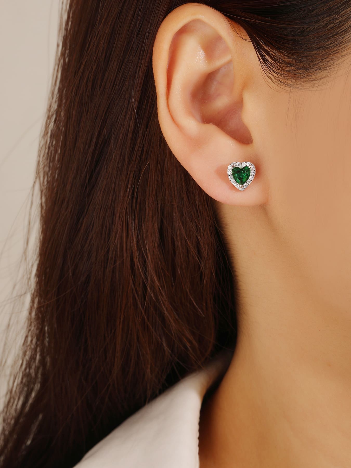 Green heart and white cubic zirconia stud earrings in hallmarked, rhodium-plated 925 sterling silver – worn view – DRESCHER Jewellery®