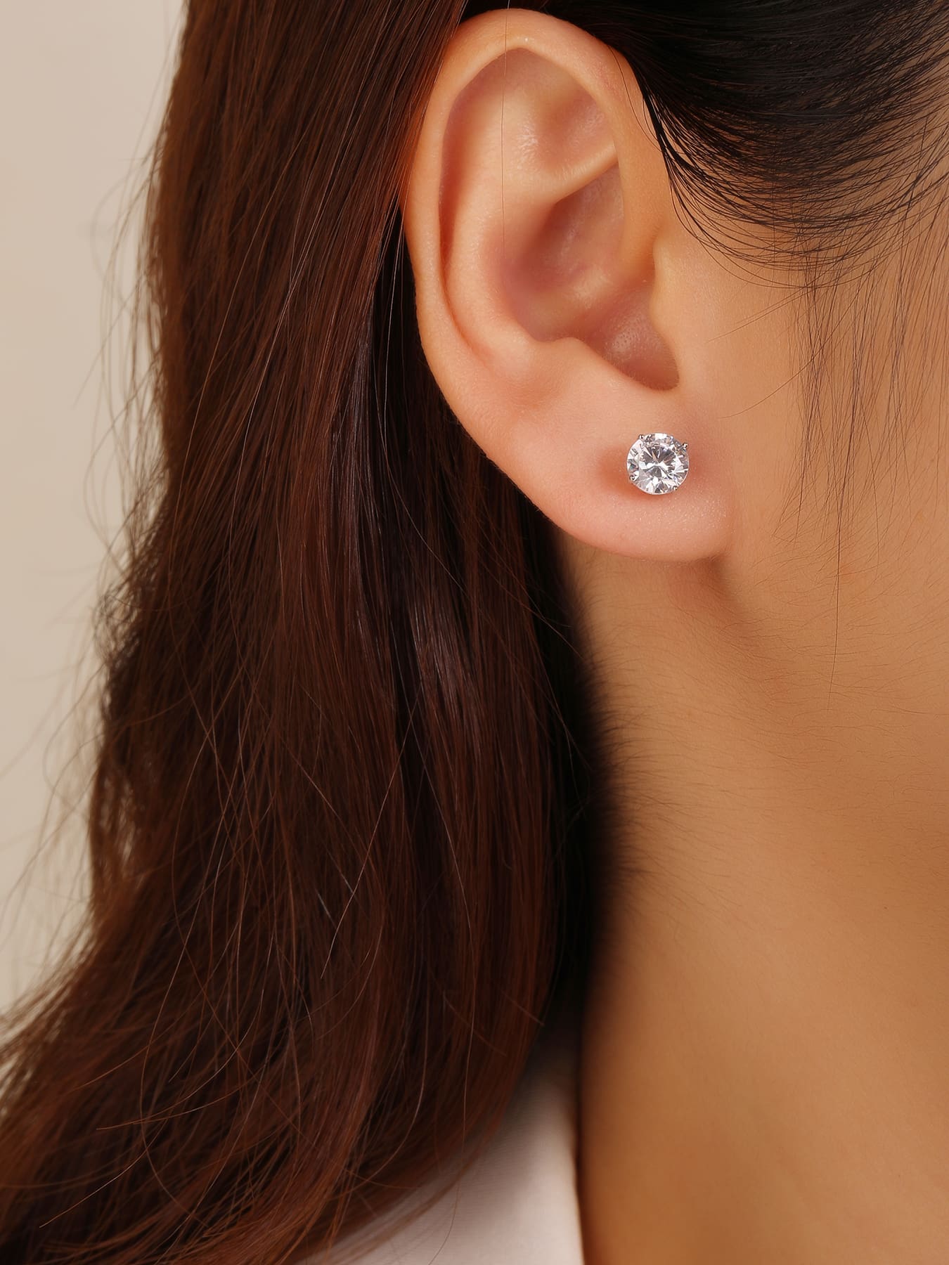 White solitaire cubic zirconia four-claw stud earrings in hallmarked, rhodium-plated 925 sterling silver – worn view – DRESCHER Jewellery®