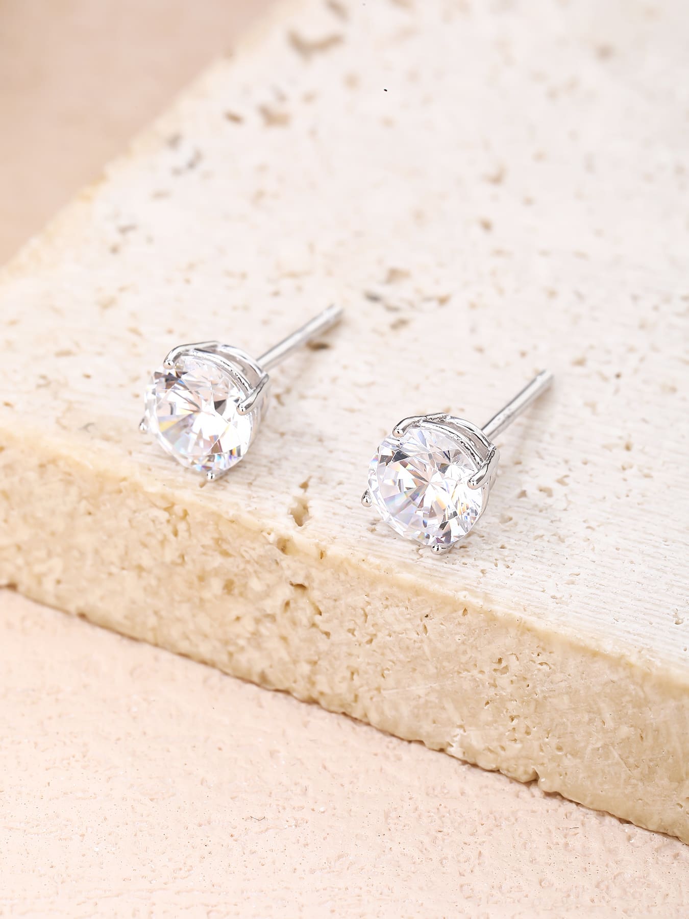 White solitaire cubic zirconia four-claw stud earrings in hallmarked, rhodium-plated 925 sterling silver – lifestyle view – DRESCHER Jewellery®