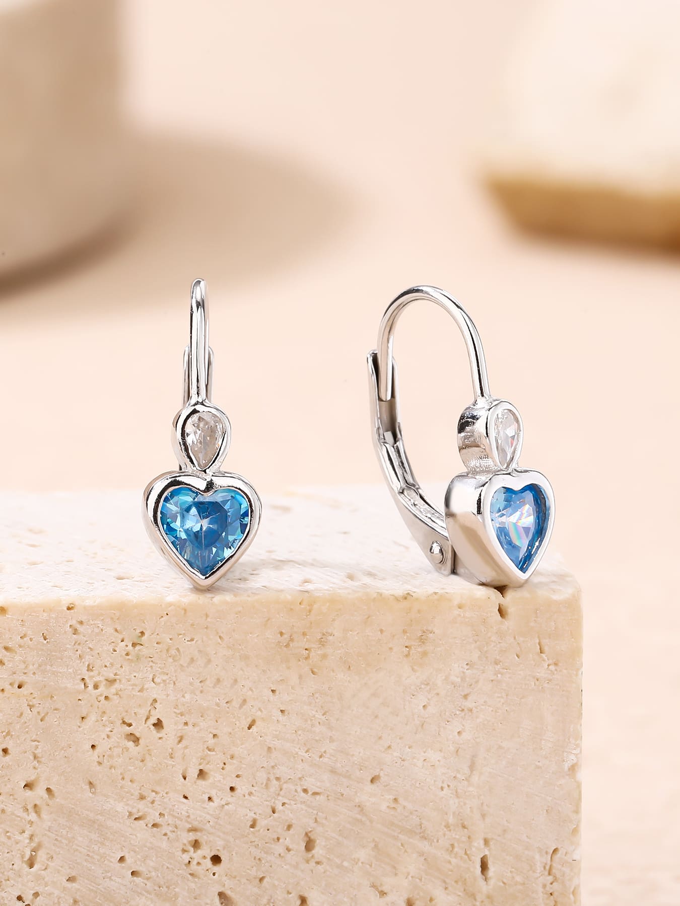 blue heart-shaped cubic zirconia children’s earrings in hallmarked, rhodium-plated 925 sterling silver – lifestyle view – DRESCHER Jewellery®