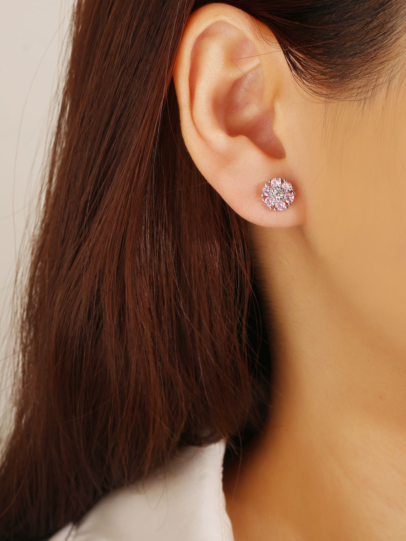 Pink and white cubic zirconia flower stud earrings in hallmarked, rhodium-plated 925 sterling silver – worn view – DRESCHER Jewellery®