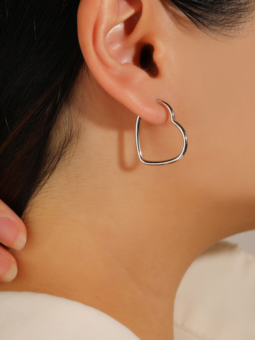 heart-shaped hoop earrings in hallmarked, rhodium-plated 925 sterling silver – worn view – DRESCHER Jewellery®