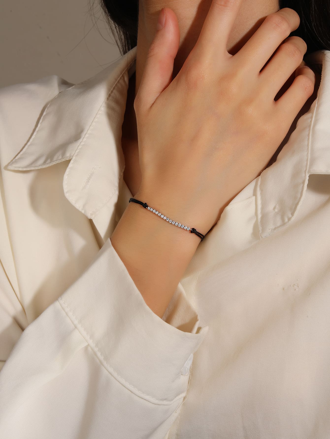 Tennis style zirconia bracelet with black cord - adjustable size (17 + 4 cm) with hallmarked, rhodium-plated 925 sterling silver motif – worn view – DRESCHER Jewellery®