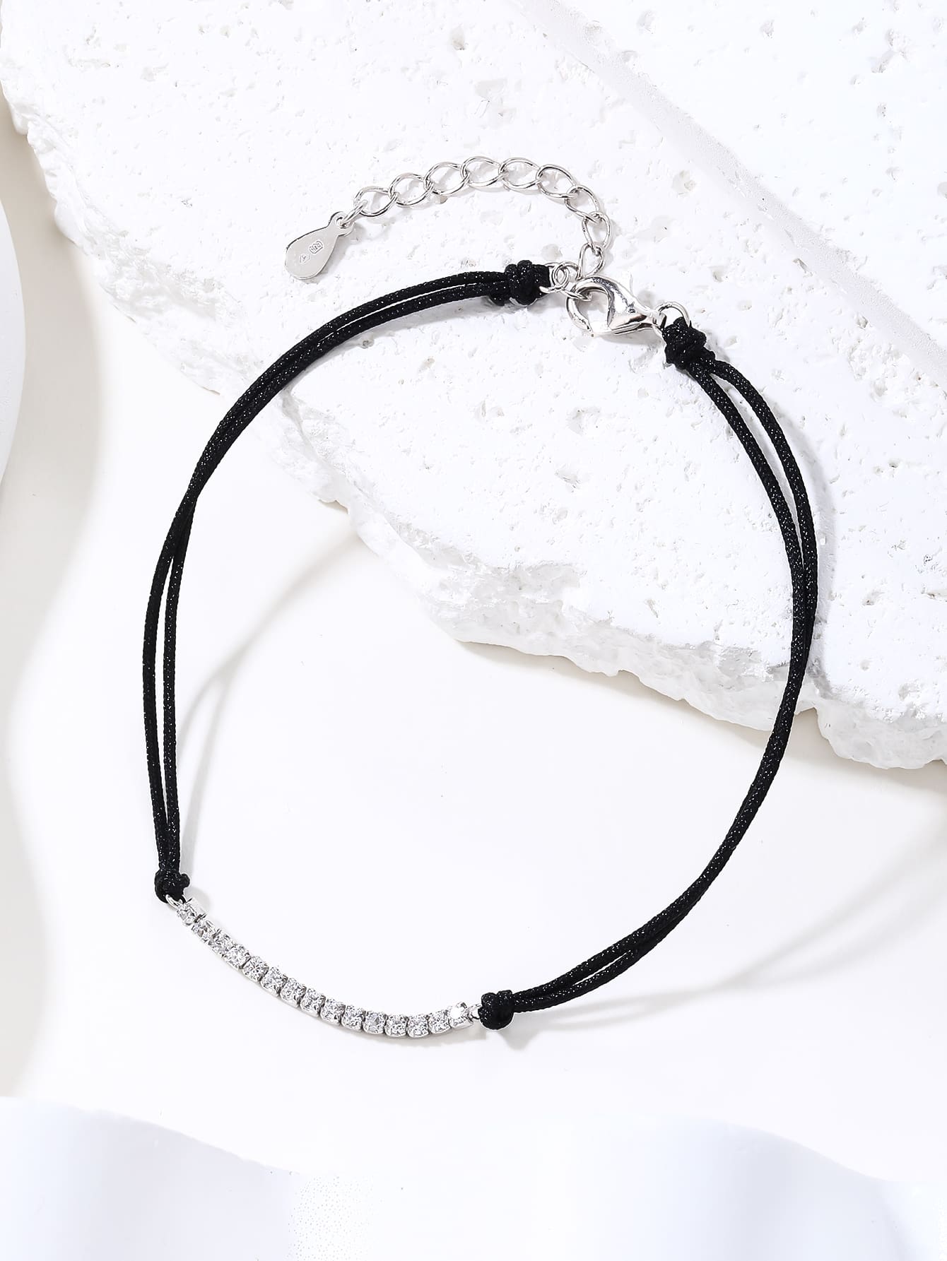 Tennis style zirconia bracelet with black cord - adjustable size (17 + 4 cm) with hallmarked, rhodium-plated 925 sterling silver motif – display view – DRESCHER Jewellery®